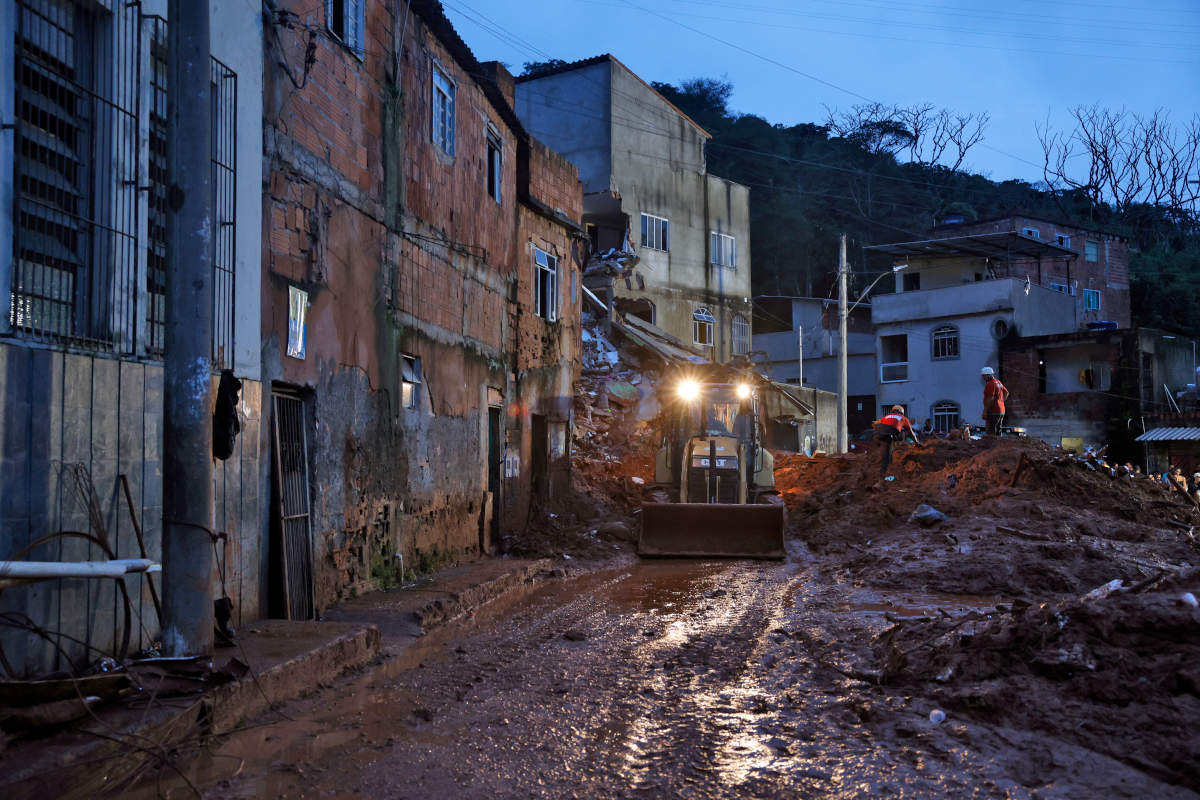 Soldados do Corpo de Bombeiros e voluntários fazem busca e resgate de pessoas em escombros de casas soterradas por lama após fortes chuvas (Foto: Tânia Rêgo/Agência Brasil)