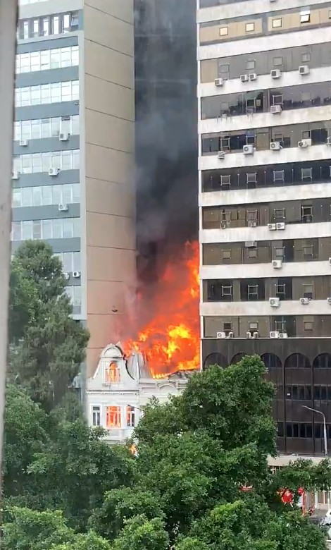 Pelo menos quatro caminhões do Corpo de Bombeiros atuam no combate às chamas, que por volta das 15h15 já haviam alcançado uma segunda loja